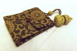 A small Oriental Purse decorated with floral fabric, strap with ivory retaining beads, total