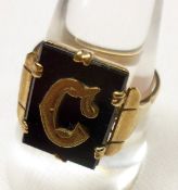 A mid-20th Century yellow metal Signet Ring, featuring the initial “C” to a rectangular black onyx