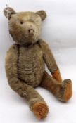 An early 20th Century Straw-Filled Mohair Teddy Bear with one amber glass eye, protruding snout with