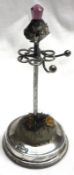 A George V Ring and Hatpin Stand, of typical form with thistle flower decoration to top, 3 ½”