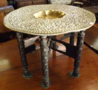 An early 20th Century Brass Tray Top Benares Table, the round top to a six-legged hardwood base with