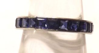 An unmarked precious metal all Mid-Blue Sapphire set Eternity Ring