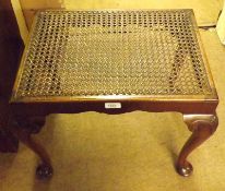 An early 20th Century Mahogany Stool with cane-work top, raised on cabriole legs with shell carved