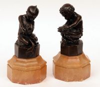 A pair of 19th Century Bronze Figures of young children, one holding a tortoise, the other a fish,