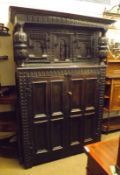 A large 19th Century Oak Court Cupboard, the top with two heavy doors with arched detail, the base