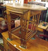 An early 20th Century Quarteto Nest of Walnut Veneered Tables, raised on turned legs, largest 27”