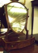 An early 19th Century Mahogany Dressing Table Mirror, of shield shape form, on a bow front base with