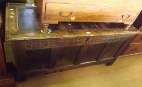 An 18th Century Oak Coffer, with three panelled top and four panelled front with carved foliage