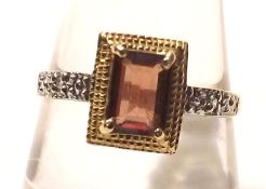 A yellow metal Centre Emerald Cut Garnet and two small Diamond Ring, stamped “10K”