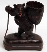 An unusual Black Forest Carved Softwood Table Centrepiece, modelled as a bear with basket to back,