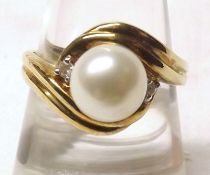 A hallmarked 9ct Gold Ring, featuring a central Cultured Pearl flanked to each side by a small