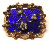A Victorian Gold Framed Brooch with scrolled edge, raised floral designs with pearl mounts to a blue