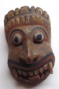 An unusual Carved Softwood Mask, modelled as a grotesque demon’s face, probably of Balinese or South