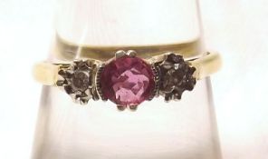 A hallmarked 18ct Gold Centre Pale Red Ruby and two small Brilliant Cut Diamond Ring, the centre