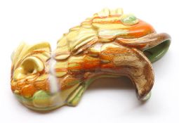 A Clarice Cliff small Fish-Shaped Wall Pocket, decorated in orange, greens and browns with streaky