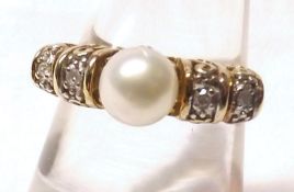 A hallmarked 9ct Gold Centre Cultured Pearl Ring, flanked to each side by two small Brilliant Cut