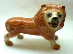 A late 19th Century Staffordshire type Model of a Lion, fitted with glass eyes, (eyes A/F), 12” long