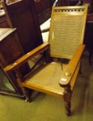 An early 20th Century Fruitwood Planters type Chair, with cane back and seat and swivelling