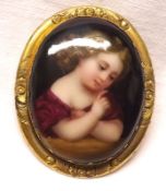 A Victorian Gilt Metal Framed Oval Brooch, featuring a hand-painted centre of a young child to a