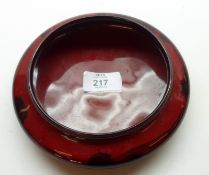A Royal Doulton Flambé Shallow Bowl, decorated with a continuous scene of cottages amongst trees,