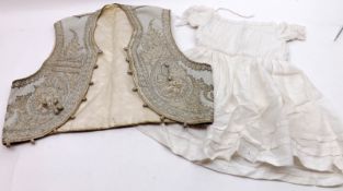 A small Vintage Child’s Waistcoat with silver thread decoration; together with a Vintage Christening