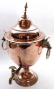 A 19th Century Copper Tea Urn with lift-off cover, applied on either side with animalistic ring
