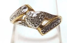 A yellow metal Ring marked 10K, centre setting with Diamond chips forming a heart