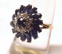 A hallmarked 18ct Gold Dress Ring, featuring fourteen Marquise Cut Mid-Blue Sapphires, centre
