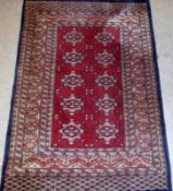 A small Caucasian Rug, multi gull border, central panel of lozenges on mainly red/rust field, 3ft