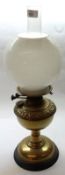 A late Victorian Oil Lamp fitted with clear glass chimney, opaque glass shade, brass font, brass