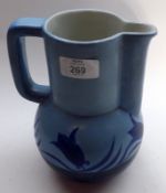 An early 20th Century Blue Glazed Jug, decorated with stylised flowers on a light blue background,