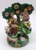 An early 19th Century Staffordshire Bocage Back Figure Group, modelled as a seated couple playing