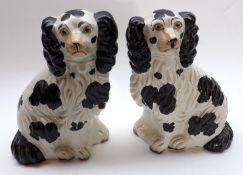 A pair of late 19th Century Staffordshire Models of seated spaniels with black body markings and