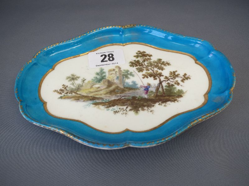 Sevres small serpentine edged dish, centrally decorated with a man fishing below a castle within a