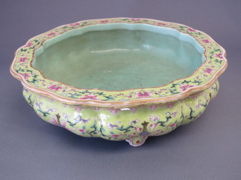 Chinese famille verte serpentine edged bowl standing on four feet, decorated flowers to a green and