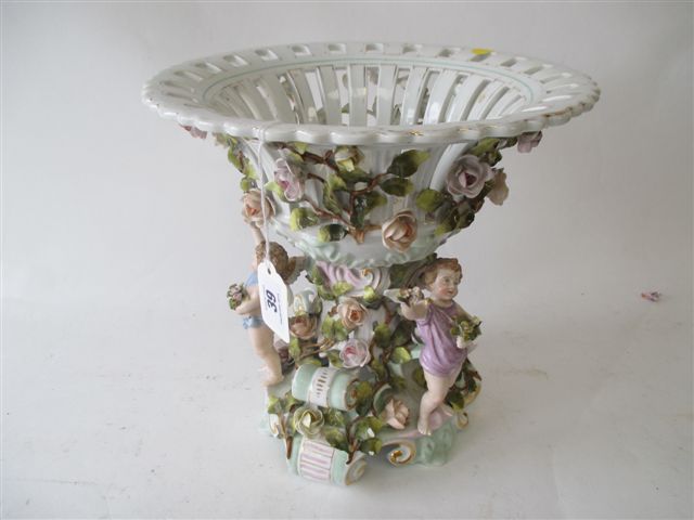 C19 continental porcelain table centrepiece, the fretted bowl supported by three winged putti