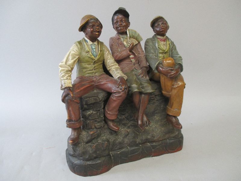 C19th American painted terracotta group with three young well dressed African American boys seated