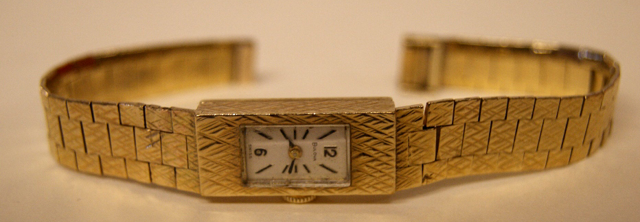 9ct yellow gold ladies dress watch by Bulova, with rectangular silvered dial having Arabic and baton