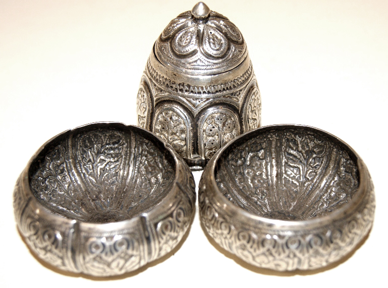 White metal repoussé decorated part cruet, with two open salts and a shaker. Eastern design
Total