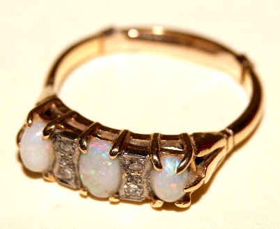 18ct yellow gold ladies dress ring, set with three opals and four small diamonds. Stamped 18ct to