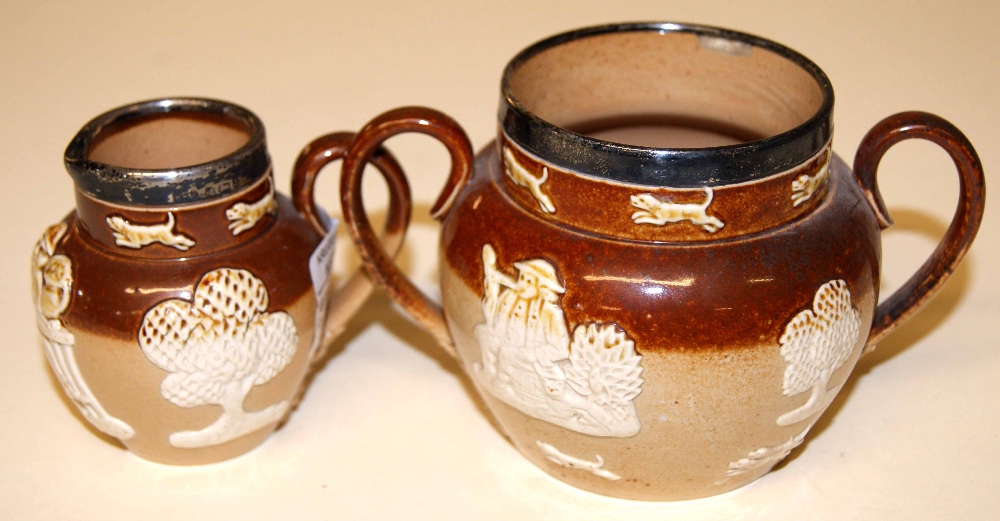 Doulton Lambeth stoneware sugar bowl and cream jug, each with applied decoration and mounted with