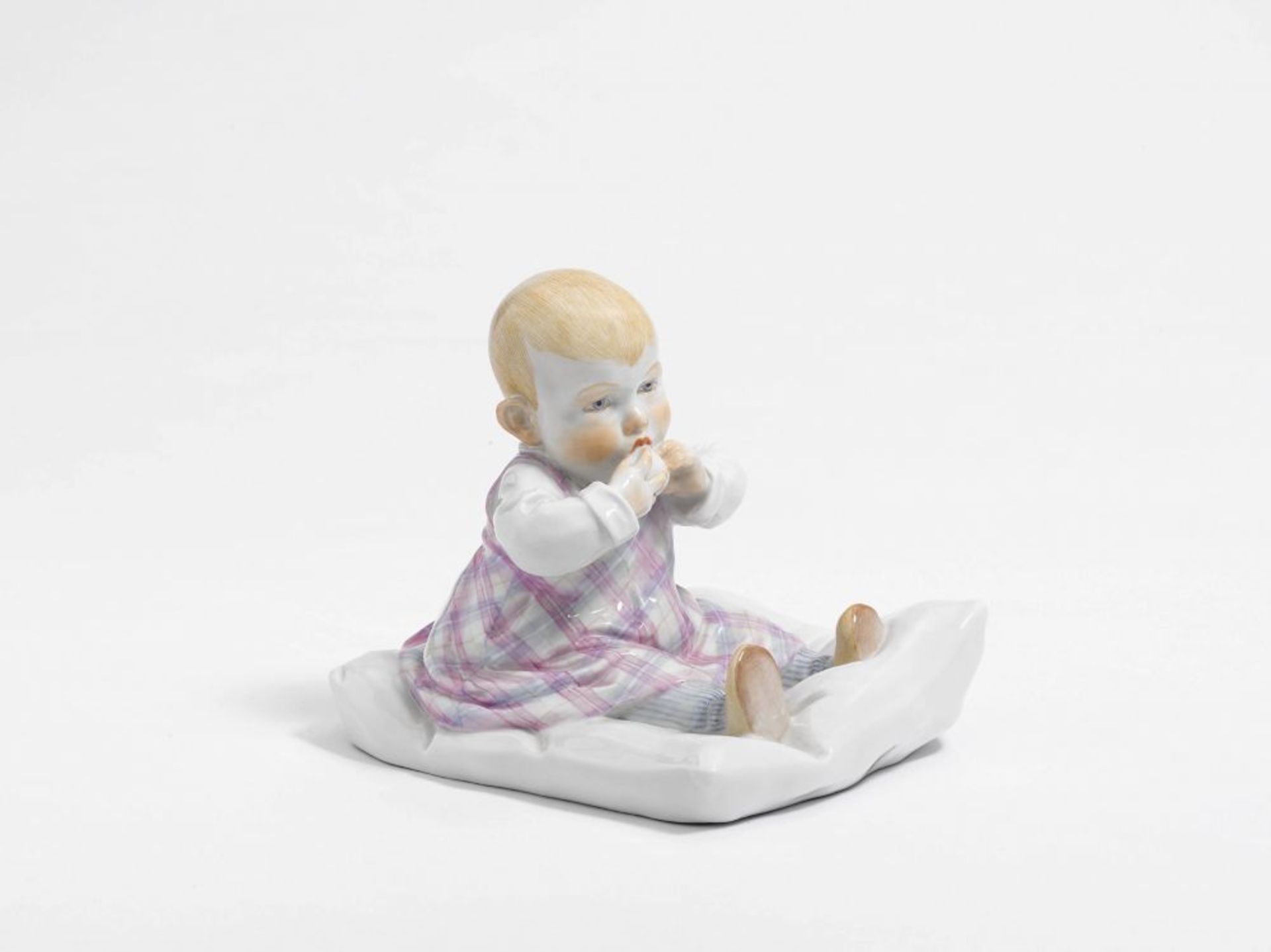 "Sitzendes Kind auf Kissen" Meissen, Entwurf Konrad Hentschel   Porzellan, bunt staffiert. Mädchen