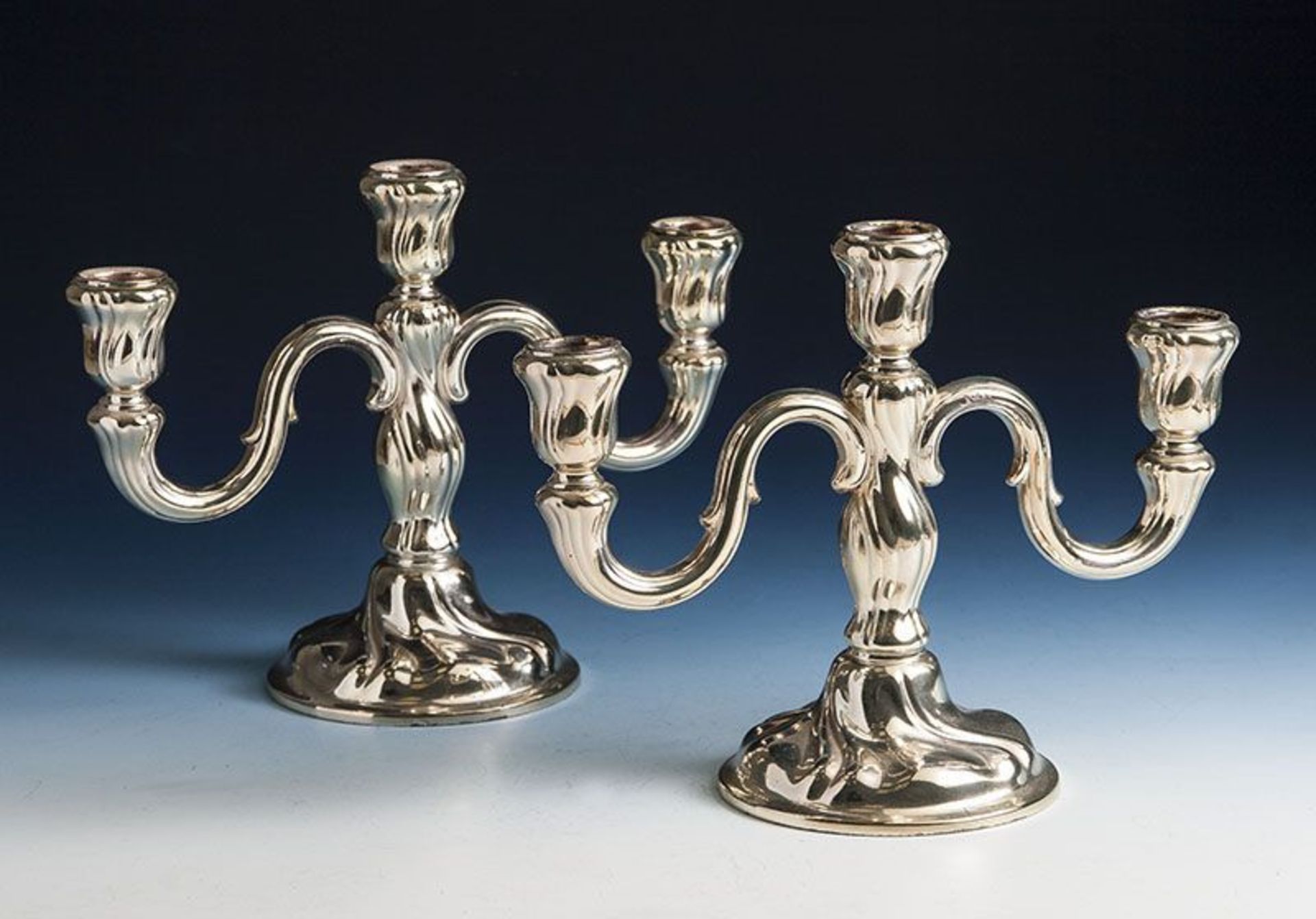 Zwei 3-flg. Kerzenhalter, 835er Silber. H. ca. 15,5 cm.    Mindestpreis: 120