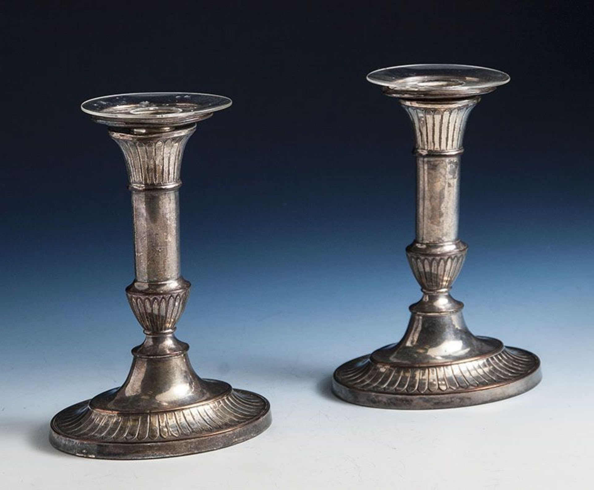 Zwei Kerzenhalter, Empirestil, Metall versilbert. H. ca. 17,5 cm.