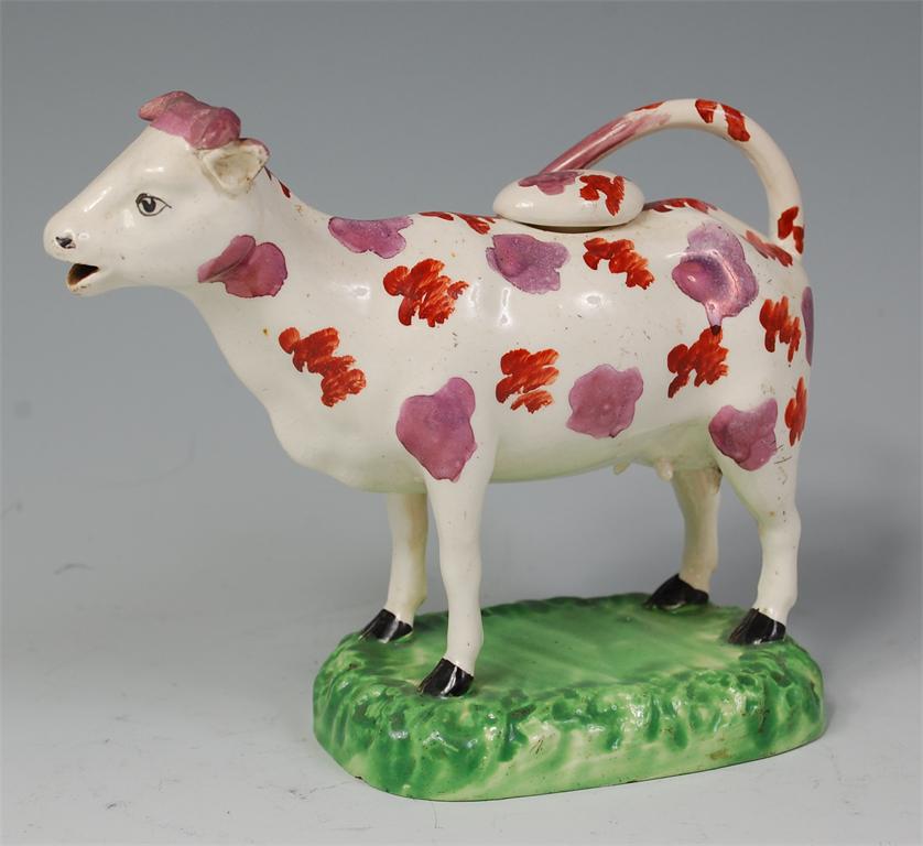 A 19th century Staffordshire cow creamer, polychrome decorated with red spots and sponge decorated