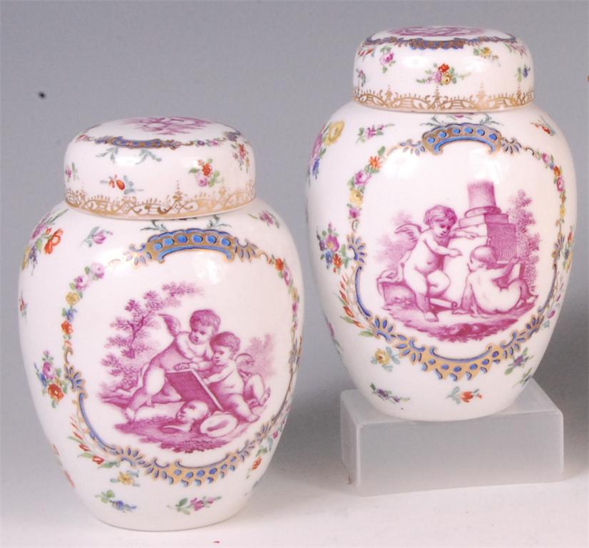 *A pair of German porcelain jars and covers, each of barrel shape and decorated with putti within
