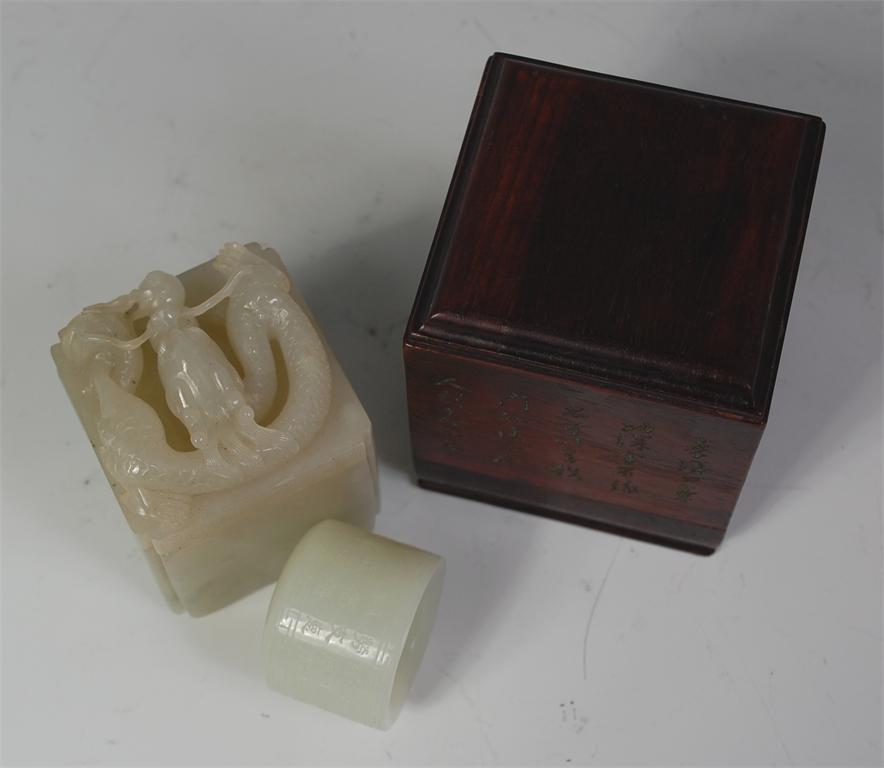 A Chinese celadon jade archers ring, engraved with bands of script and in jade box, the cover carved