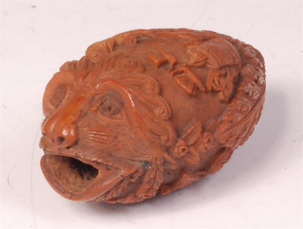 An 18th century finely carved coquilla nut, in the form of a grotesque mask with open mouth, the
