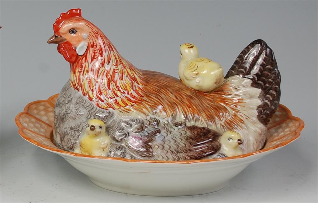 # A Dresden porcelain egg-crock, in the form of a nesting hen with chicks, decorated in bright