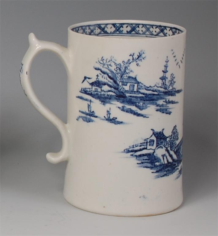 An 18th century Lowestoft porcelain tankard, underglaze blue decorated with a chinoiserie landscape,